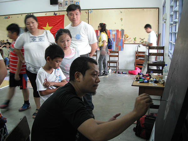 Khách tham quan đang chú ý theo dõi từng đường bút của họa sĩ Nguyễn Trần Cường.